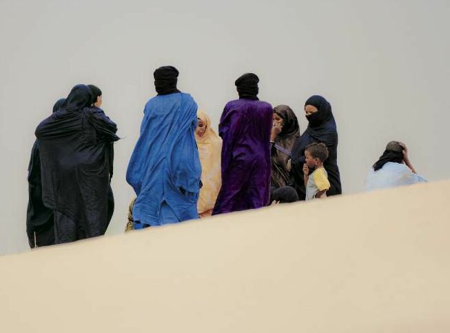 Famille touareg au loin dans une dune